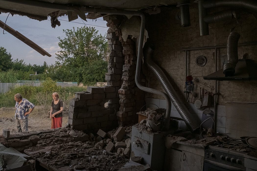 上个月在斯洛文斯克，一对夫妇站在被炸毁的家外。