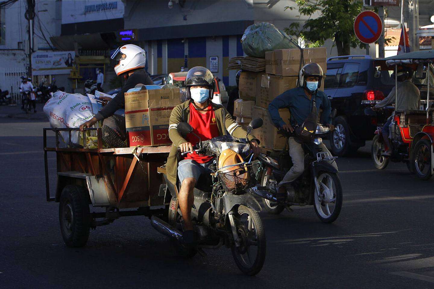 柬埔寨新冠肺炎疫情：图为12月8日金边一名司机骑电单车送货。 （AP）