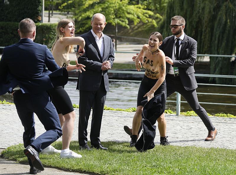 德国总理萧兹今天在总理府遇到两名女性抗议人士，当时两人走上前似乎想跟萧兹合照，却突然脱掉上衣。 (美联社)