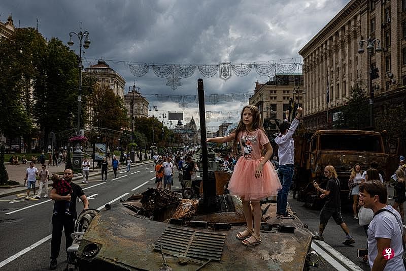 俄罗斯军队几个月前从乌克兰首都基辅撤退后，遭摧毁的坦克等俄军装备仍遗留在市中心，当地民众视为“战利品”。一名女孩在迎接乌克兰独立日之际，站在这些“战利品”上拍照留念。（法新社）