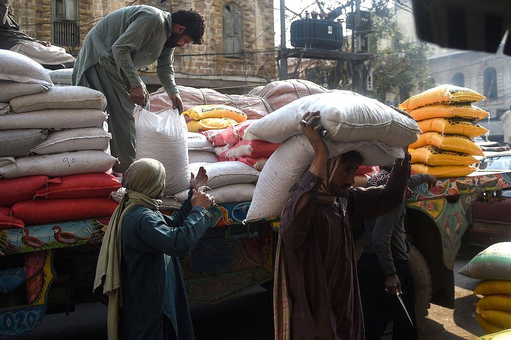 1月，工人在卡拉奇的一个市场卸大米。疫情期间食品价格上涨导致人们对汗处理经济的方式感到不满。他的继任者夏巴兹·谢里夫面临着类似的挑战。