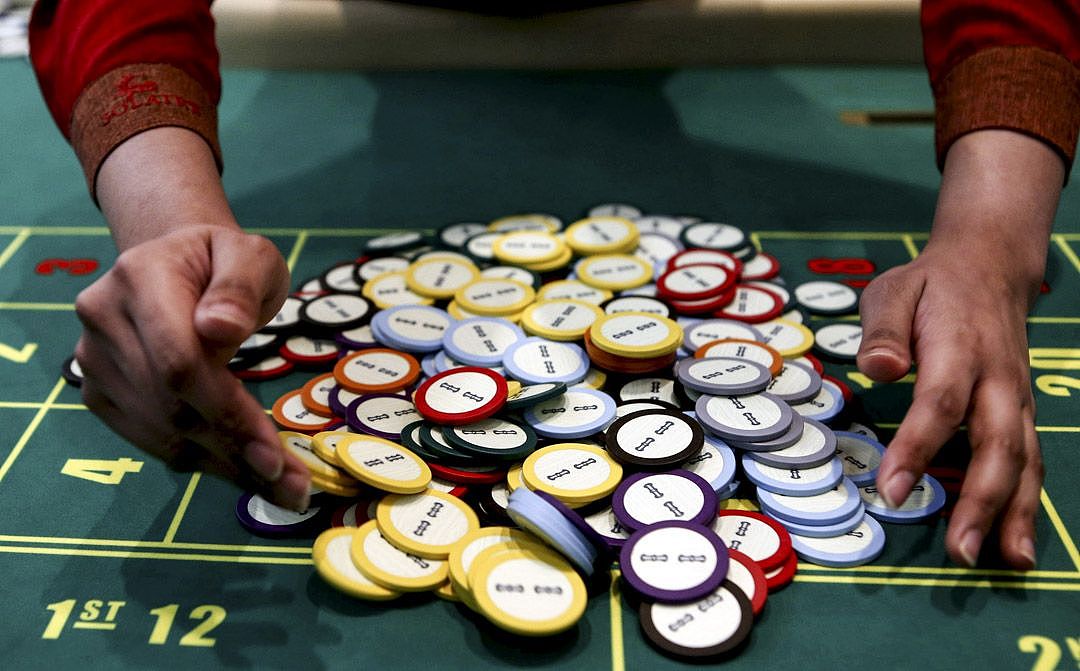 2015年3月27日，菲律宾马尼拉，一名赌场工作人员在赌桌上收集筹码。