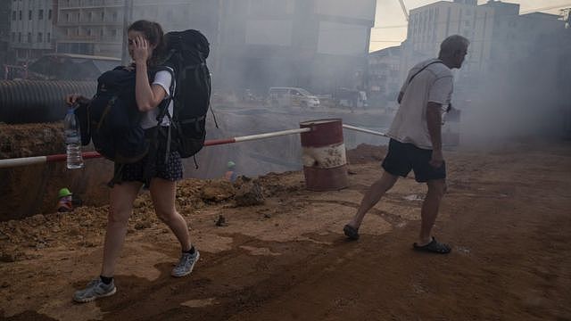 柬埔寨西哈努克市（西港）一位西方女性背包客走过一片沙尘滚滚的工地（资料图片）