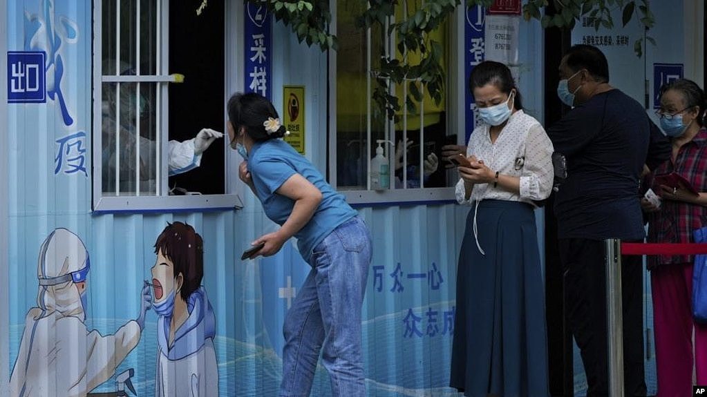 （2022年8月29日）北京居民在一条街道上接受日常新冠病毒咽拭子检测。（美联社照片）