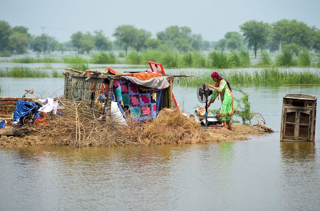 巴基斯坦三分之一的國土淹在水中，當地婦女將僅存的家當安置在地勢較高處。路透
