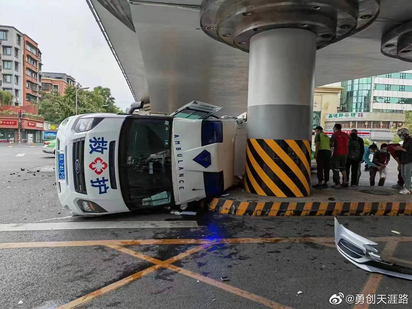 救护车被撞后翻侧，车身滑行至桥墩下。 （微博＠勇创天涯路）