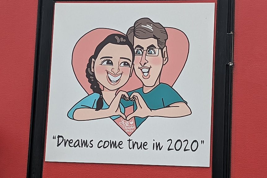 一幅漫画上印着一对夫妇，两人都穿着蓝色衬衫，对着镜头比心