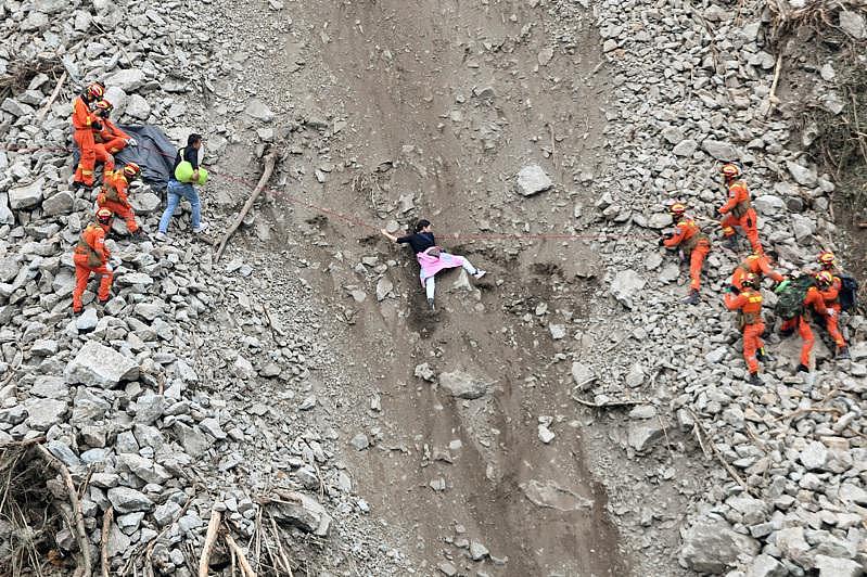 四川甘孜州瀘定縣5日發生6.8級地震，已造成82人遇難。圖為瀘定磨西鎮出現嚴重山崩，救援人員在幫助民眾撤離。（路透）