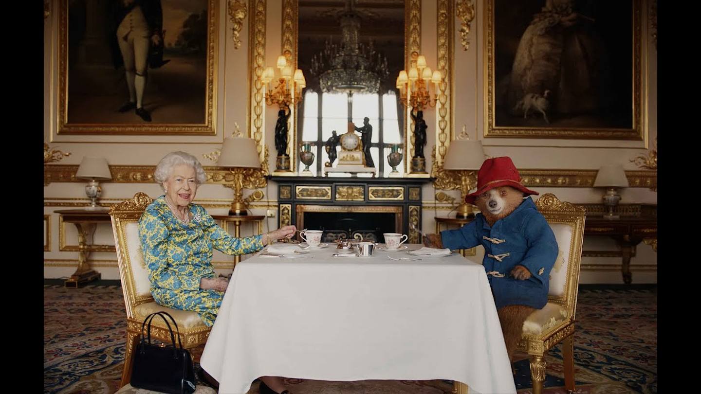 英女王與卡通角色柏靈頓熊，於慶祝女王登基70年的影片中聯乘亮相。（影片截圖）