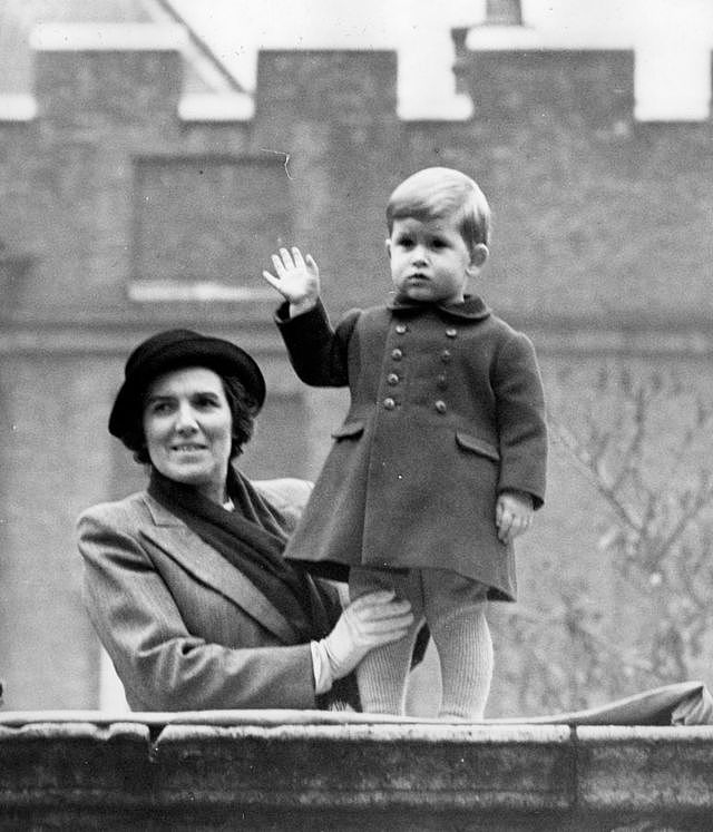 年幼的查尔斯被保姆扶着站在克拉伦斯宫墙上向时任国王和王后的外祖父外祖母携伊丽莎白公主驱车前往西敏寺国会大厦参加重要仪式。