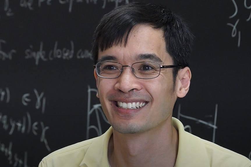 Mathematician Terry Tao in front of a blackboard.