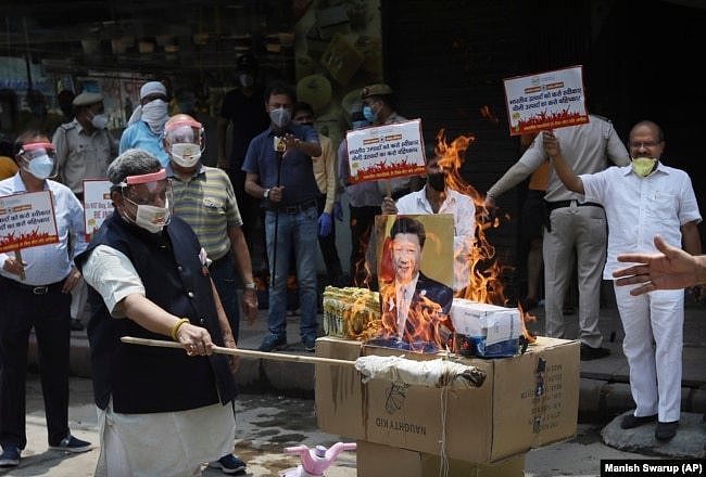 资料照片：2020年6月的中印边境冲突后，在印度新德里举行的一次抗议活动中，印度商人焚烧中国商品和中国国家主席习近平的海报。（2020年6月22日）