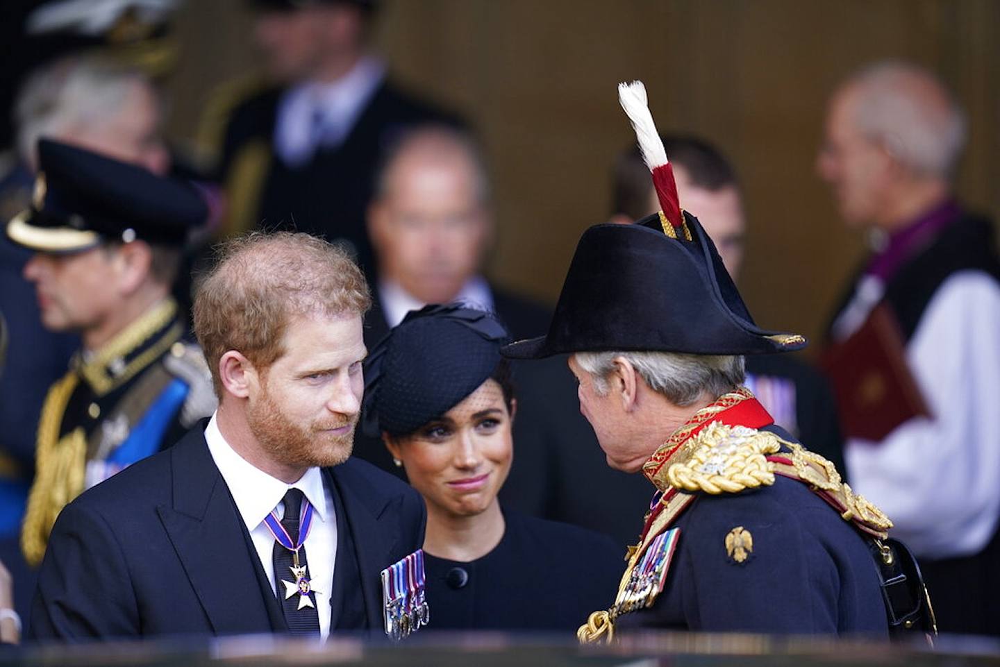 由於梅根的言行富爭議，她往往成為媒體焦點，甚至有報道認為她看似在微笑的表情，是對女王不敬。圖為2022年9月14日，哈里王子夫人梅根離開倫敦西敏廳。（AP）
