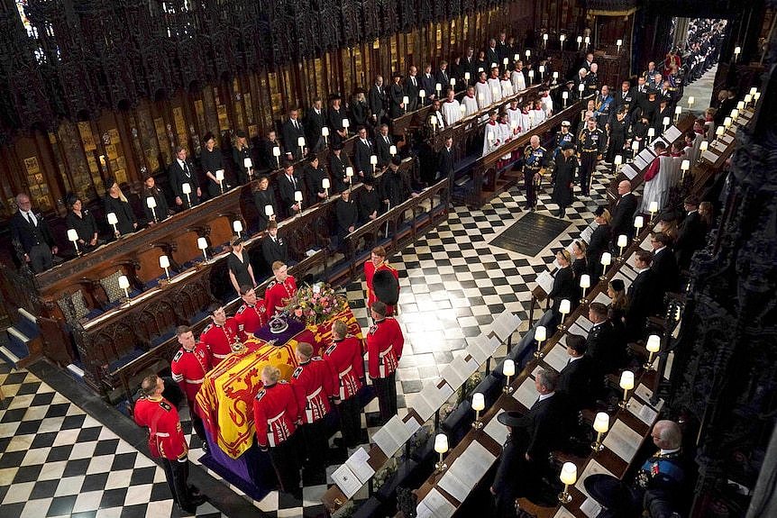 The Queen's coffin in the centre of St George's Chapel surrounded by mourners.