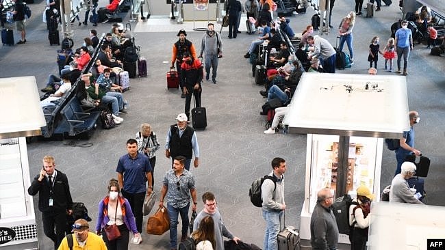 2022年4月19日，在联邦法官宣布对公共交通系统的口罩要求不再有效的一天后，美国科罗拉多州丹佛机场航站楼内一些准备搭机的乘客，已经不再佩戴口罩。