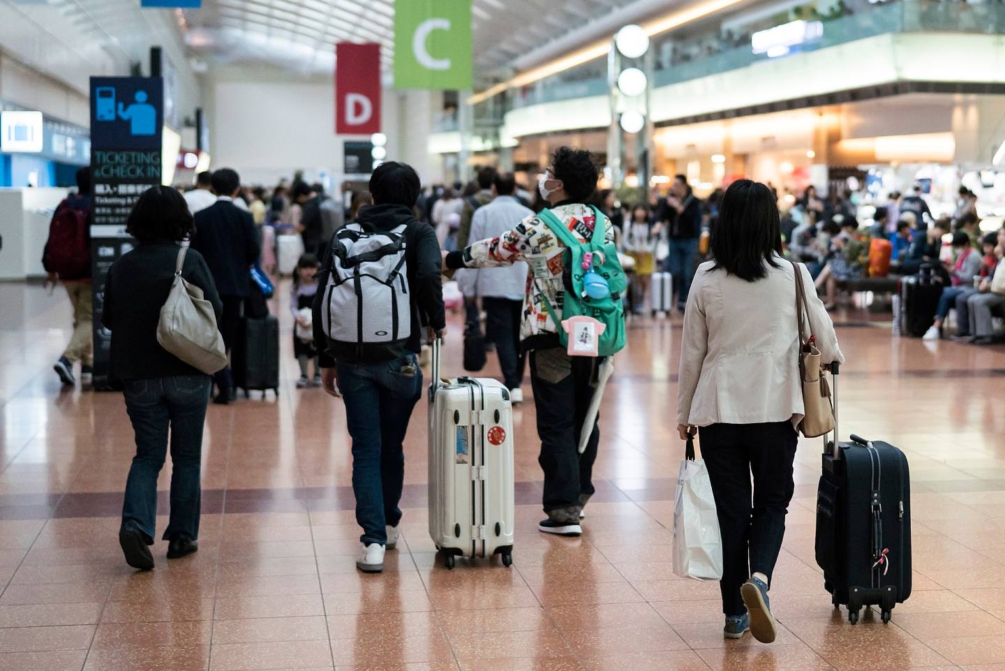 圖為2019年4月27日，黃金週假期的第一天，日本東京的乘客在羽田機場攜着行李行動。日本人的黃金週，是指4月底至5月初由多個節日組成的公眾假期，這是日本旅遊業及相關行業最繁忙的一星期。（Getty）