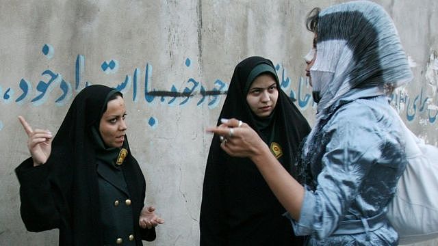 伊朗道德女警在德黑兰与一名妇女谈论她的着装（2007年4月22日资料照片）。