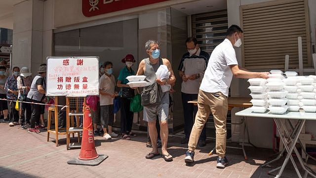 香港九龙红磡一群老年人排队领取志愿者派发的免费盒饭（11/9/2022）