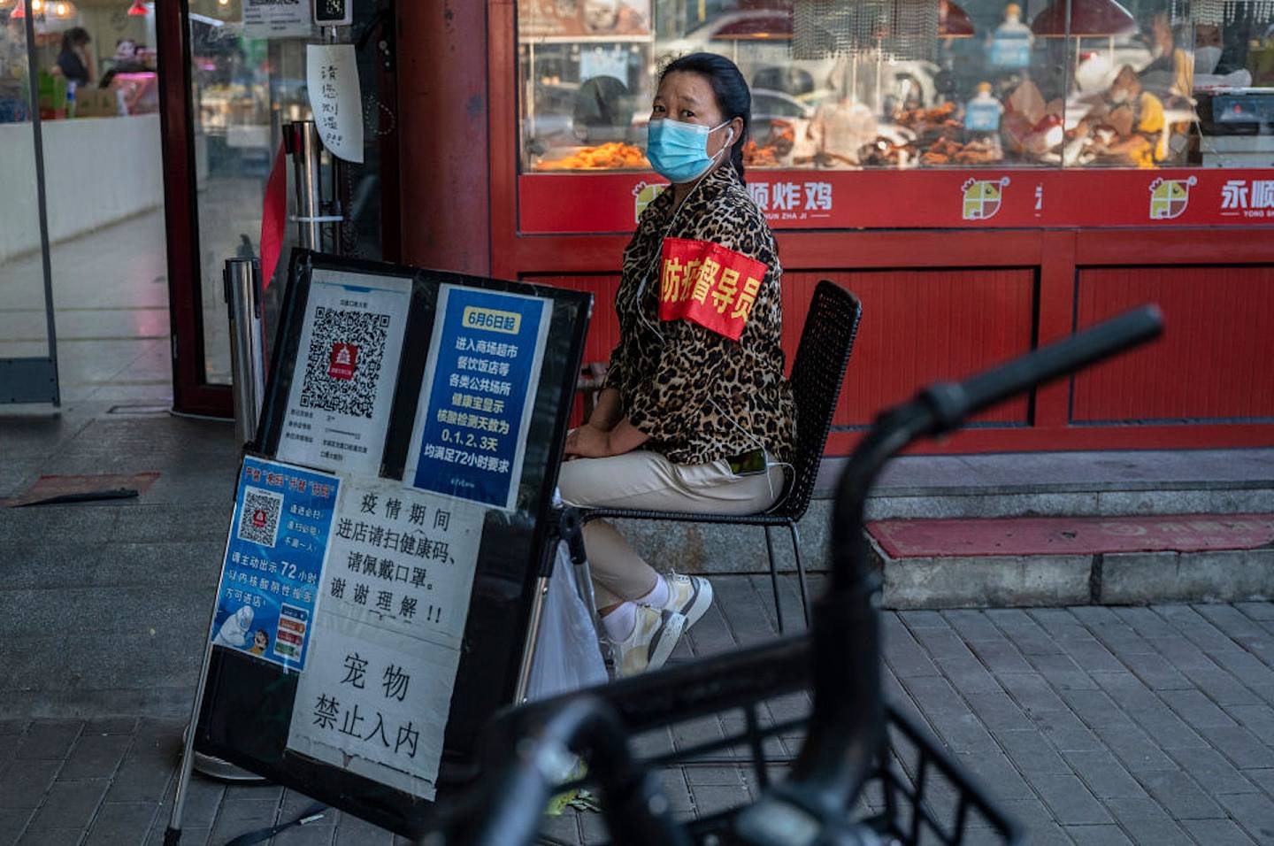 北京7月6日，一名社區志願者坐在健康碼旁邊。（Getty Images）