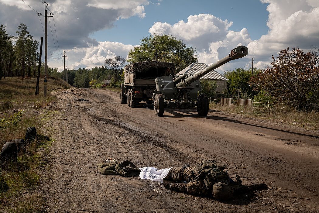 周六，在乌克兰奥斯基尔，一台俄罗斯大炮被拖走，路边躺着俄罗斯士兵的尸体。