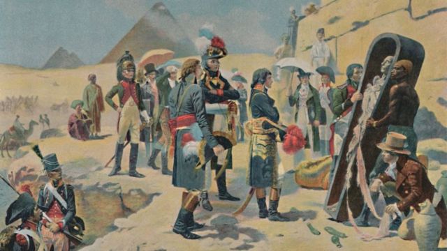 图为法国军人注视着棺椁中的木乃伊