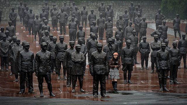 游客在成都建川博物馆的1931-1945年抗日战争纪念碑前走过中国领导人和士兵的雕像。
