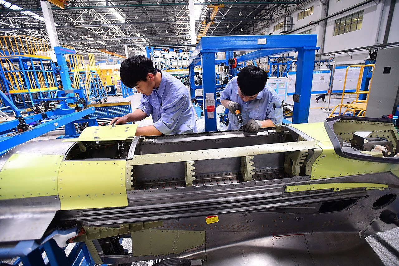 2018 年 3 月 14 日，辽宁省沈阳飞机公司一工厂，工人在组装中国本土研发C919 客机发动机。（路透社）