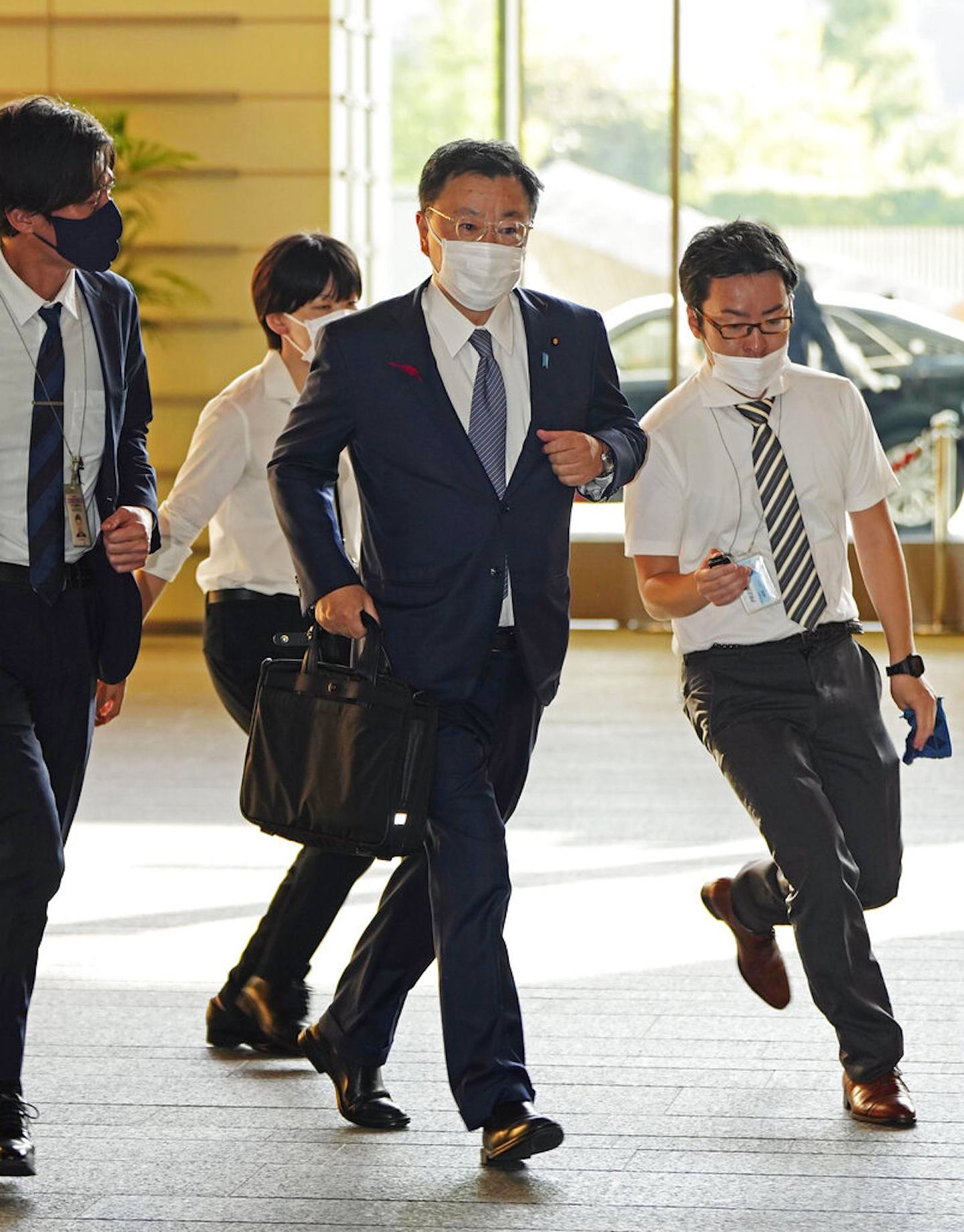 图为2022年10月4日，日本内阁官房长官松野博一抵达首相办公室时的情形，他看来相当匆忙。 （AP）