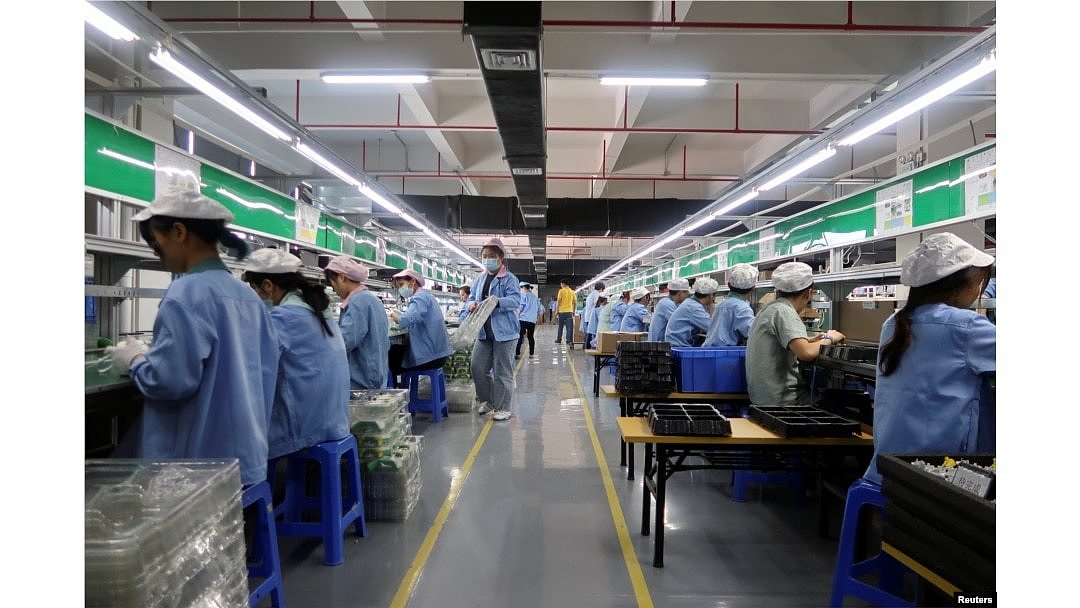 中国广东东莞的工人为一家美国公司的RiotPWR移动游戏控制器在生产线上工作。（2021年12月7日）