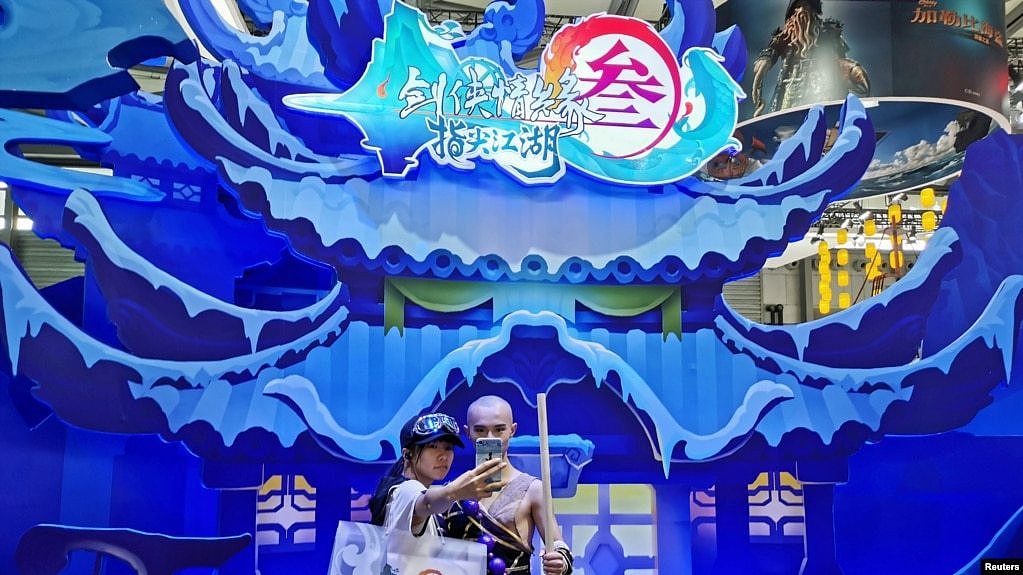 中国国际数码互动娱乐展览会在上海举办期间一名女子与腾讯游戏出品的一款电子游戏中的一角色扮演者合影。（2019年8月2日） 