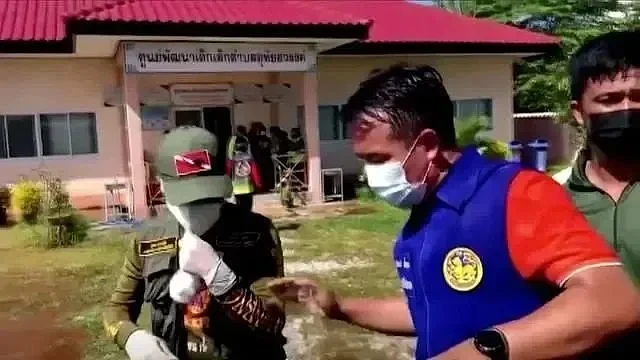 10月6日，在泰国农磨兰普，警察在发生枪击案的儿童日托中心外警戒（视频截图） 来源：新华社/路透