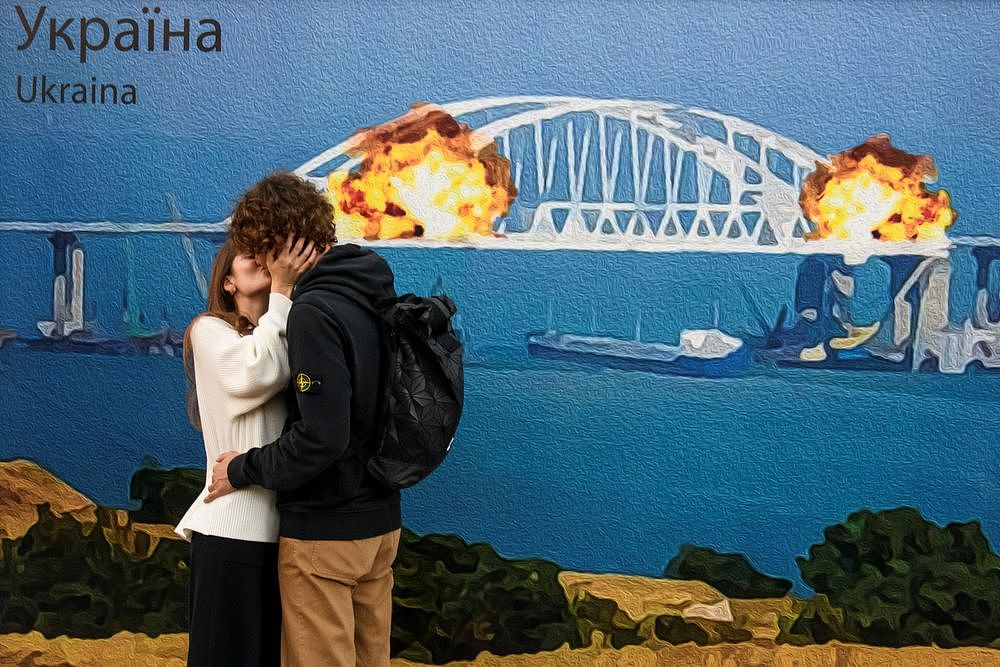 乌克兰民众10月8日在基辅，于克里米亚大桥被炸的巨型涂鸦看板前拍照留念。 路透社