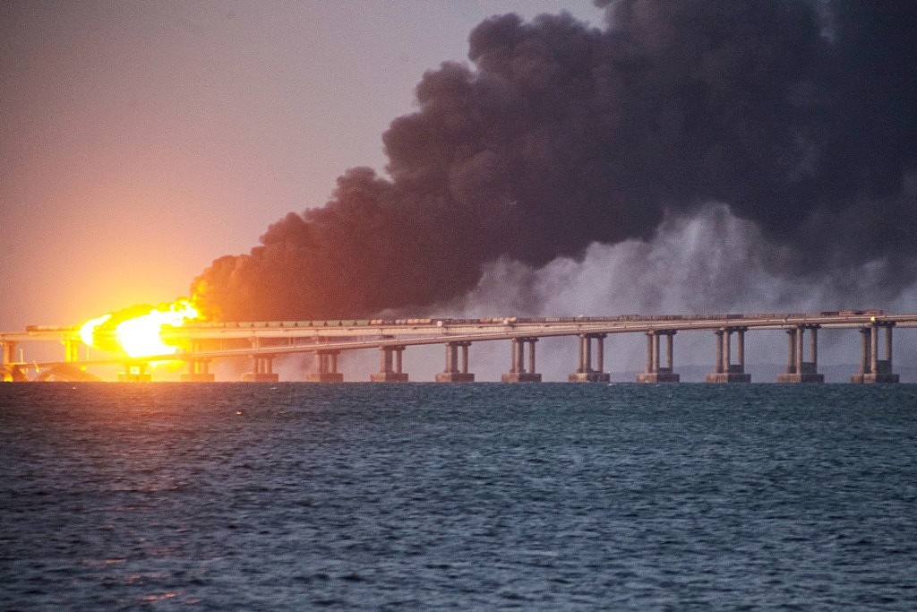 俄罗斯克里米亚大桥8日遭到攻击，莫斯科称一辆卡车炸弹引爆炸毁桥梁，不过外媒指出，爆炸前不久海面上突然涌出「神秘波浪」，怀疑真正的攻击来源并非卡车炸弹，而是船只安装的炸弹或装载炸弹的无人机。 （图／美联社）