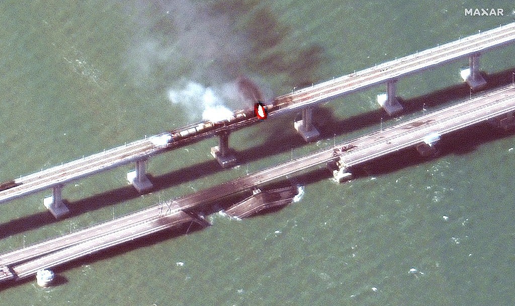俄罗斯克里米亚大桥8日遭到攻击、爆炸，美国马萨尔科技（Maxar Technologies）同日公布桥梁断裂、起火的卫星画面。 （图／美联社、马萨尔科技提供）