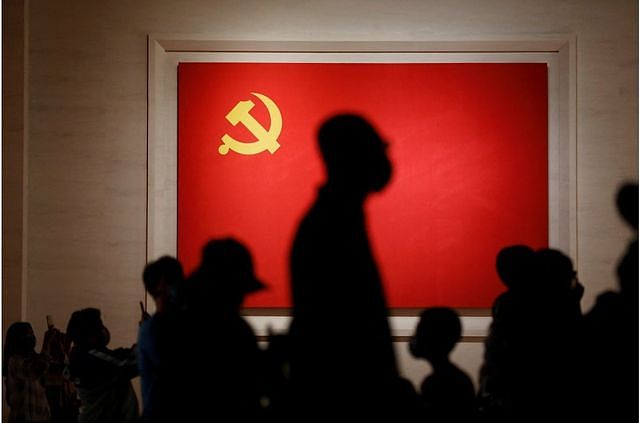 位于北京的中国共产党博物馆内，游客们在展出的中共党旗前的剪影。