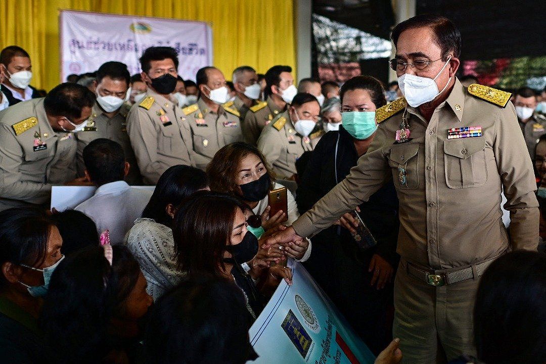 泰国首相巴育（右）上周五向受害者家属颁发国家补偿的支票后，与家属们交谈与握手致慰问。（图取自法新社）