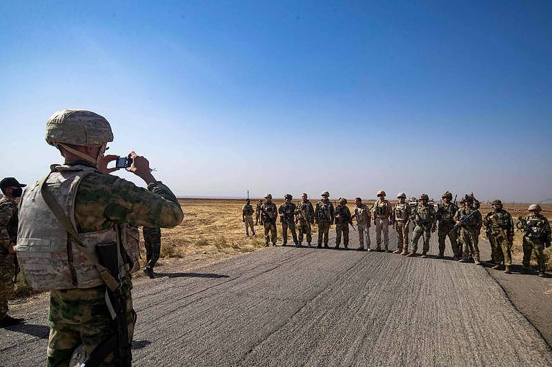 一隊駐敘利亞美軍上週六與俄軍巡邏隊在哈塞克省的卡塔尼亞鎮不期而遇，雙方士兵一起拍了一系列合照。（法新社）