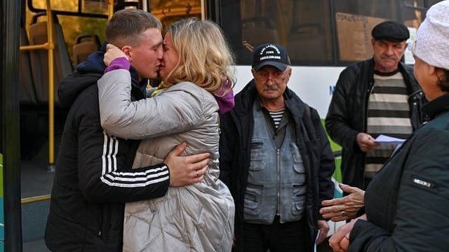 俄罗斯西伯利亚鄂木斯克一名被征召入伍的男子与女亲友吻别（7/10/2022）