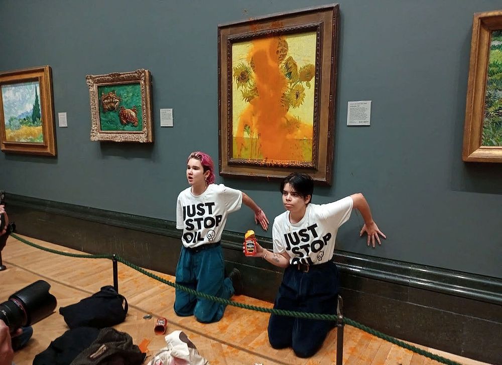 環保人士在英國倫敦國家美術館朝梵谷《向日葵》潑番茄汁，再把手黏在牆上抗議。踏透社