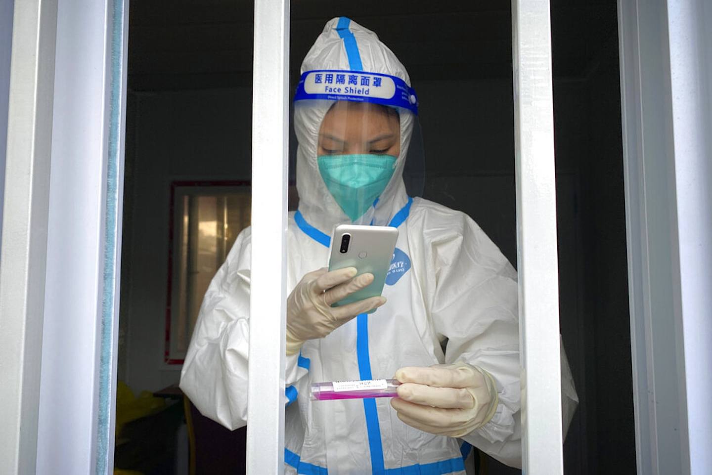 圖為10月14日，北京一個檢測站，工作人員正進行新冠檢測。防疫清零政策預料會持續。（AP）
