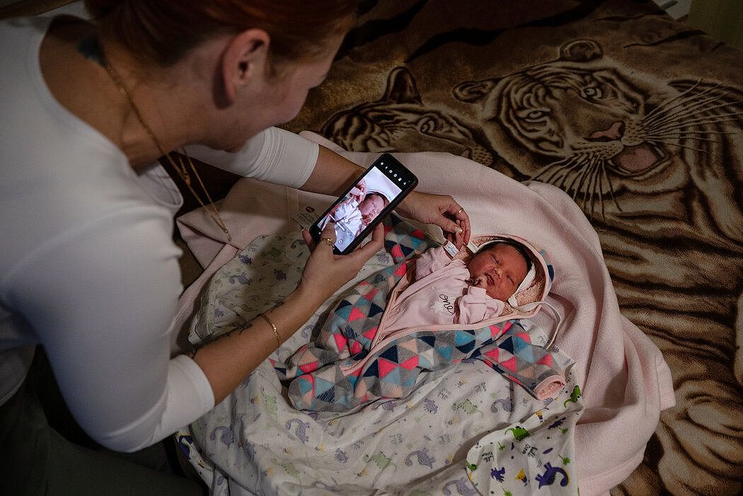 布科斯夫卡给代孕母亲生下的婴儿拍照，然后把照片发给孩子的生理父母。