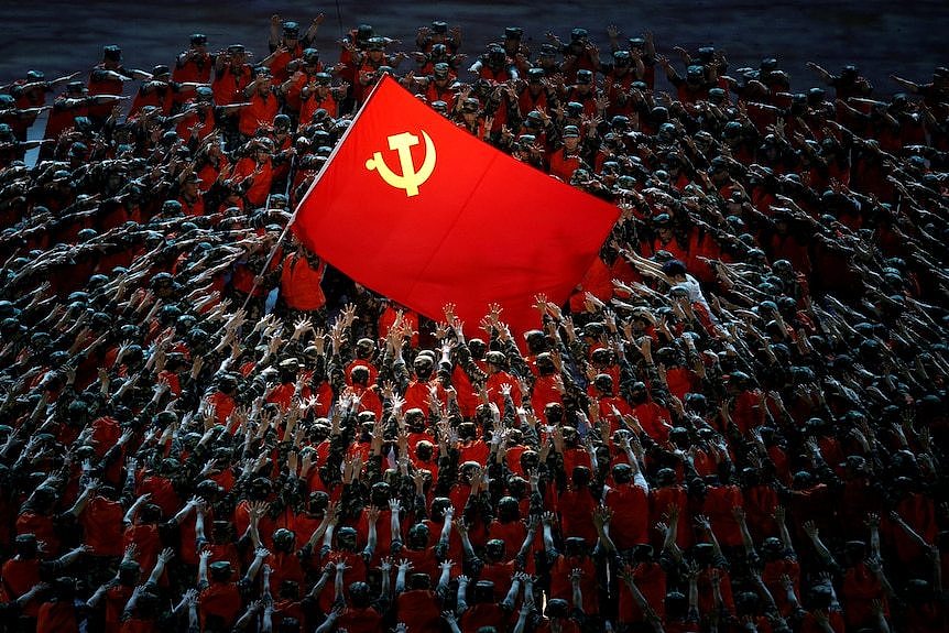 在2021年纪念中国共产党成立100周年的演出中，表演者们聚集在红旗周围。