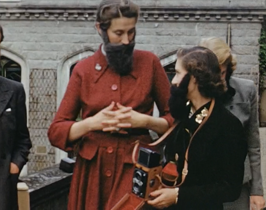 伊丽莎白二世戴着大胡子拿着Rolleiflex TLR相机出席一场活动。 图...