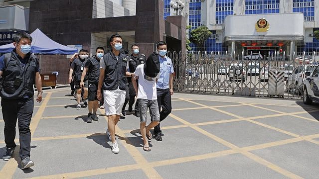 广东广州某公安办公大楼前警员押解嫌犯（中新社图片16/5/2022）