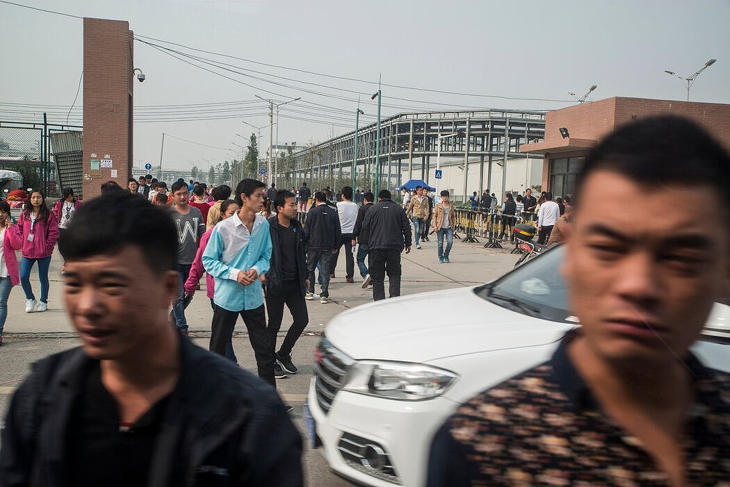 2015年，在中国郑州富士康工厂外，工人们走出来吃午饭。