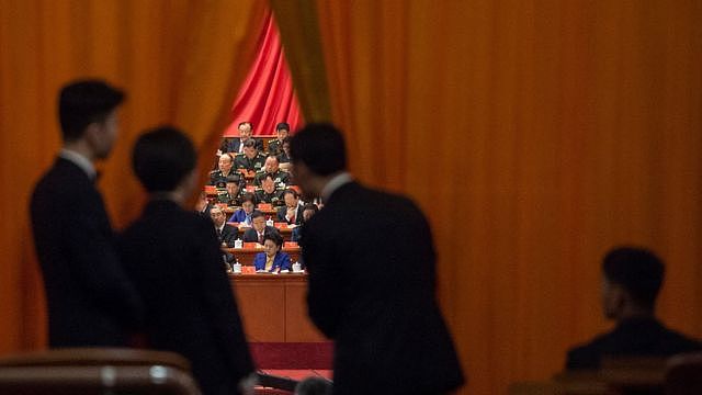 Chinese security guards look at military delegates during the speech of Chinese President Xi Jinping at the Communist Party's 19th Congress in Beijing on October 18, 2017