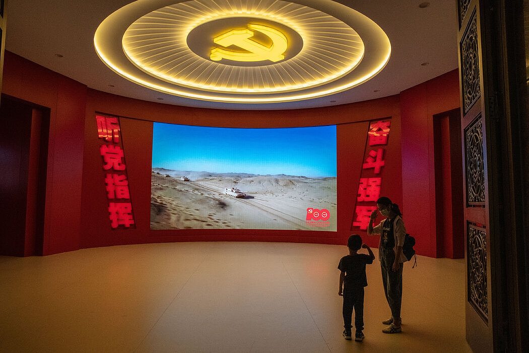 北京军事博物馆，一名年轻游客观看解放军宣传片。