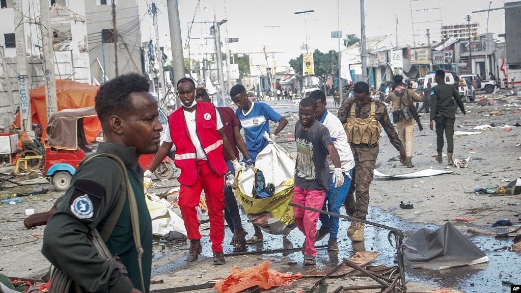 10月29日，在索马里首都摩加迪沙，救援人员从两起汽车炸弹袭击现场搬离一具尸体。