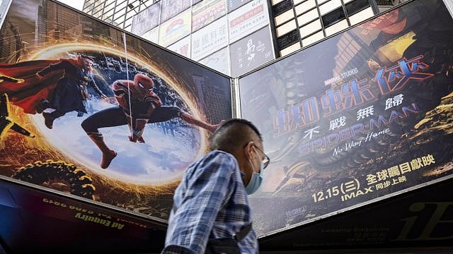 A pedestrian walks past an advertisement billboard from Marvel comics character Spider-Man 
