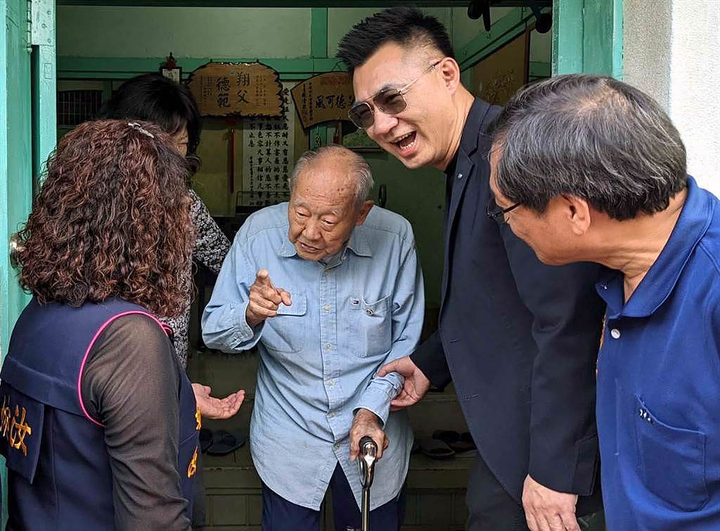 國民黨立委江啟臣（右二）2年前頒發榮譽狀給當時105歲的資演黨員金英（左二）。金英雖然行動不便，仍親自送江到門口。（潘建志攝）